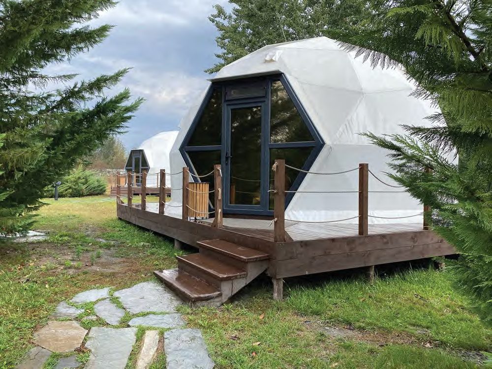 Glamping domes with hexagonal glass entrances on wooden decks