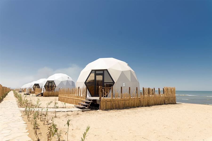 Geo-Dome L8MD on a sandy beach beside a thatched hut