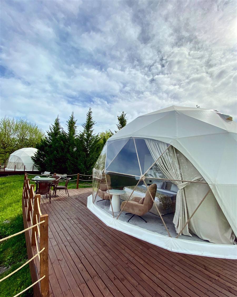 Geo-Dome M7MD with glass front and armchairs on a wooden deck